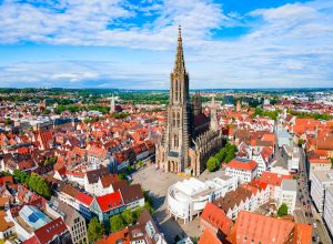Ulm Minster seen from above with its tall main tower and the spacious square in front of the church.