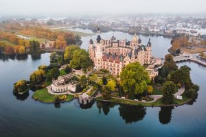 Aerial view of Schwerin Castle on an island surrounded by water and landscaped grounds