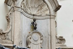 The photo shows the Manneken Pis statue in Brussels, Belgium.