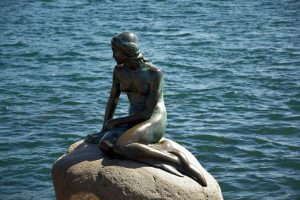 The Little Mermaid sits on a rock by the water in Copenhagen, Denmark.