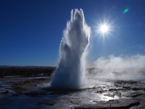 A tall column of water erupts from the Strokkur geyser in Iceland.