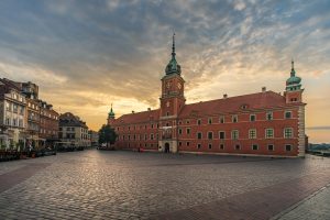 Royal Castle in Warsaw on Castle Square beneath a heavily clouded sky.