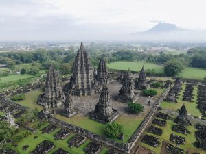 The image shows the Hindu Prambanan temple complex with its tall stone towers on the Indonesian island of Java.