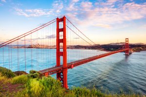 Golden Gate Bridge from an elevated perspective above the water with the cityscape in the background